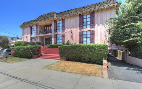 a pink house with a sidewalk in front of it