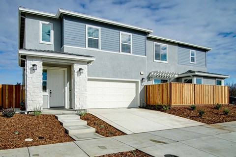 a blue house with a sidewalk in front of it