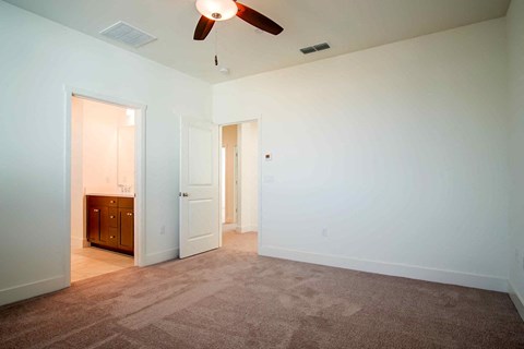 a room with a carpeted floor and a ceiling fan