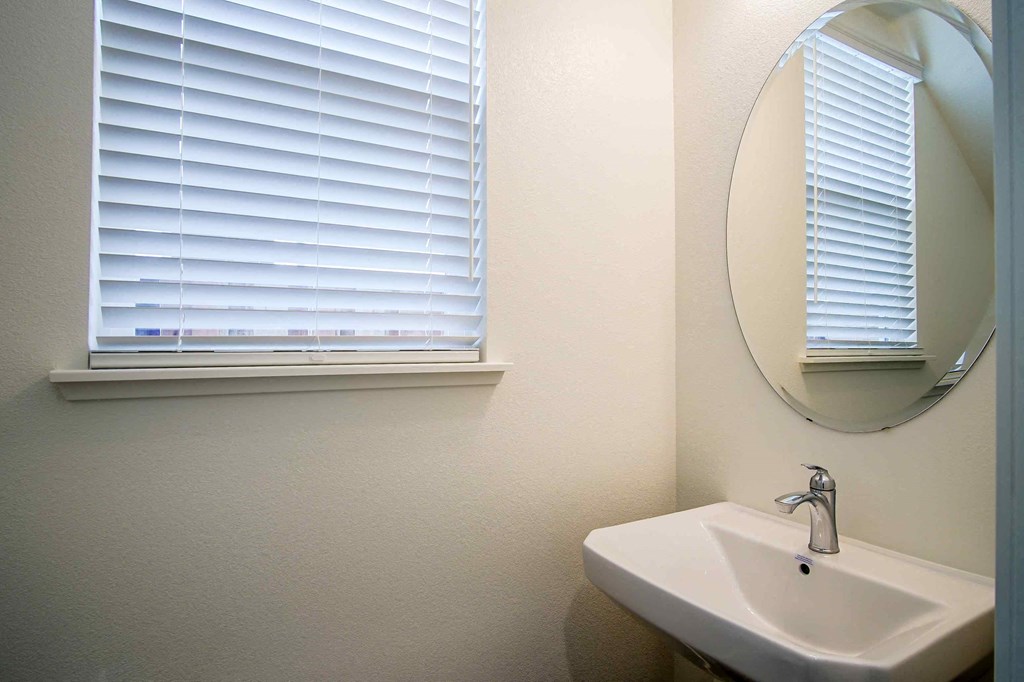 a bathroom with a sink and a mirror and a window