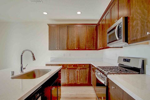 a kitchen with wooden cabinets and a sink and a microwave