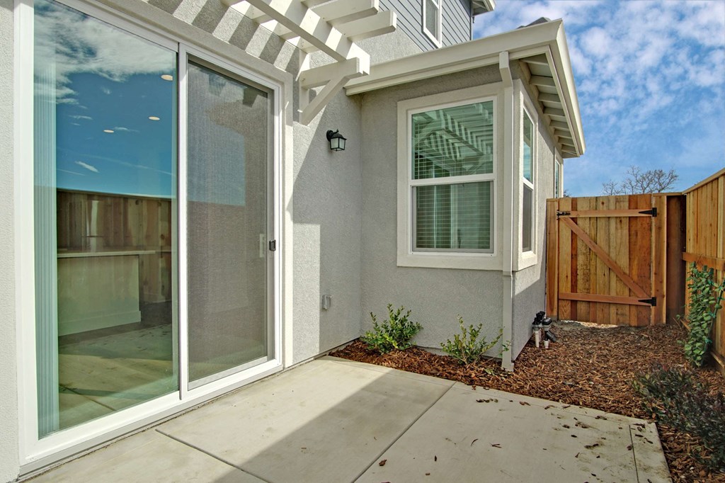 a side view of a house with a patio and glass doors