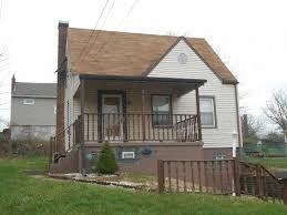A small house with a brown roof and a brown fence.