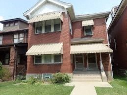 A red brick house with a white awning.