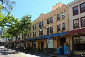 A street view of a row of buildings with a blue sky above.