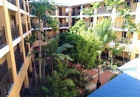 A view of a courtyard with trees and a pool from a balcony.