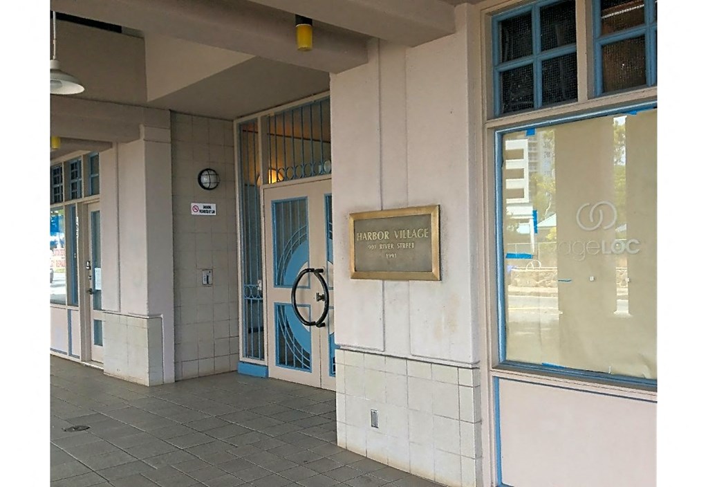 the front of a building with a door and a clock on the side