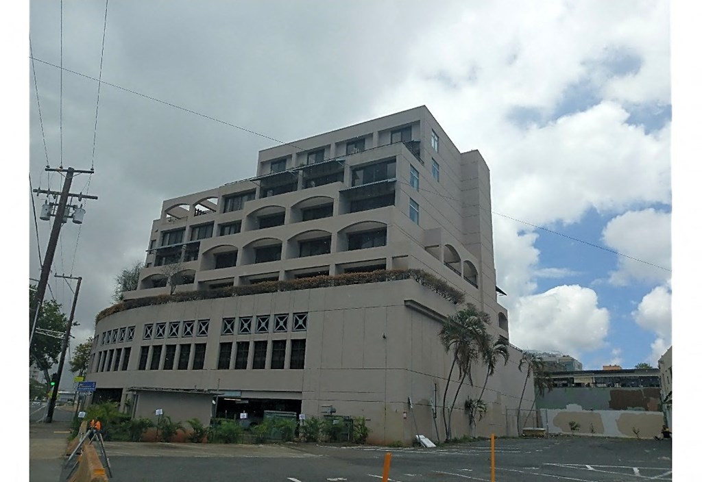 a large white building with a cloudy sky in the background