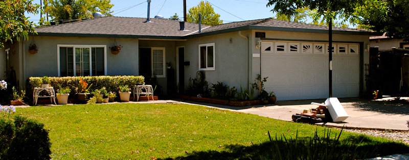 A house with a white garage door and a brown roof.