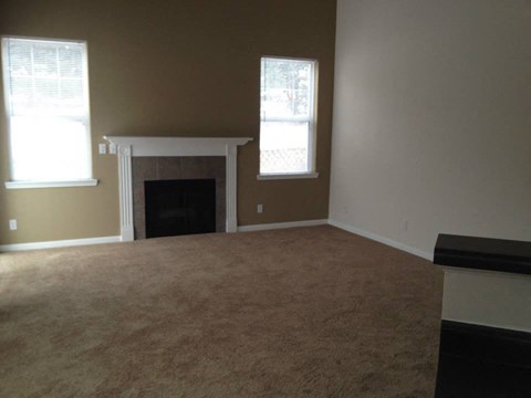 an empty living room with a fireplace