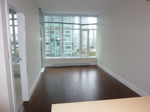 A room with a large window and wooden floors.