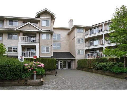 A large apartment complex with a no parking sign in front.