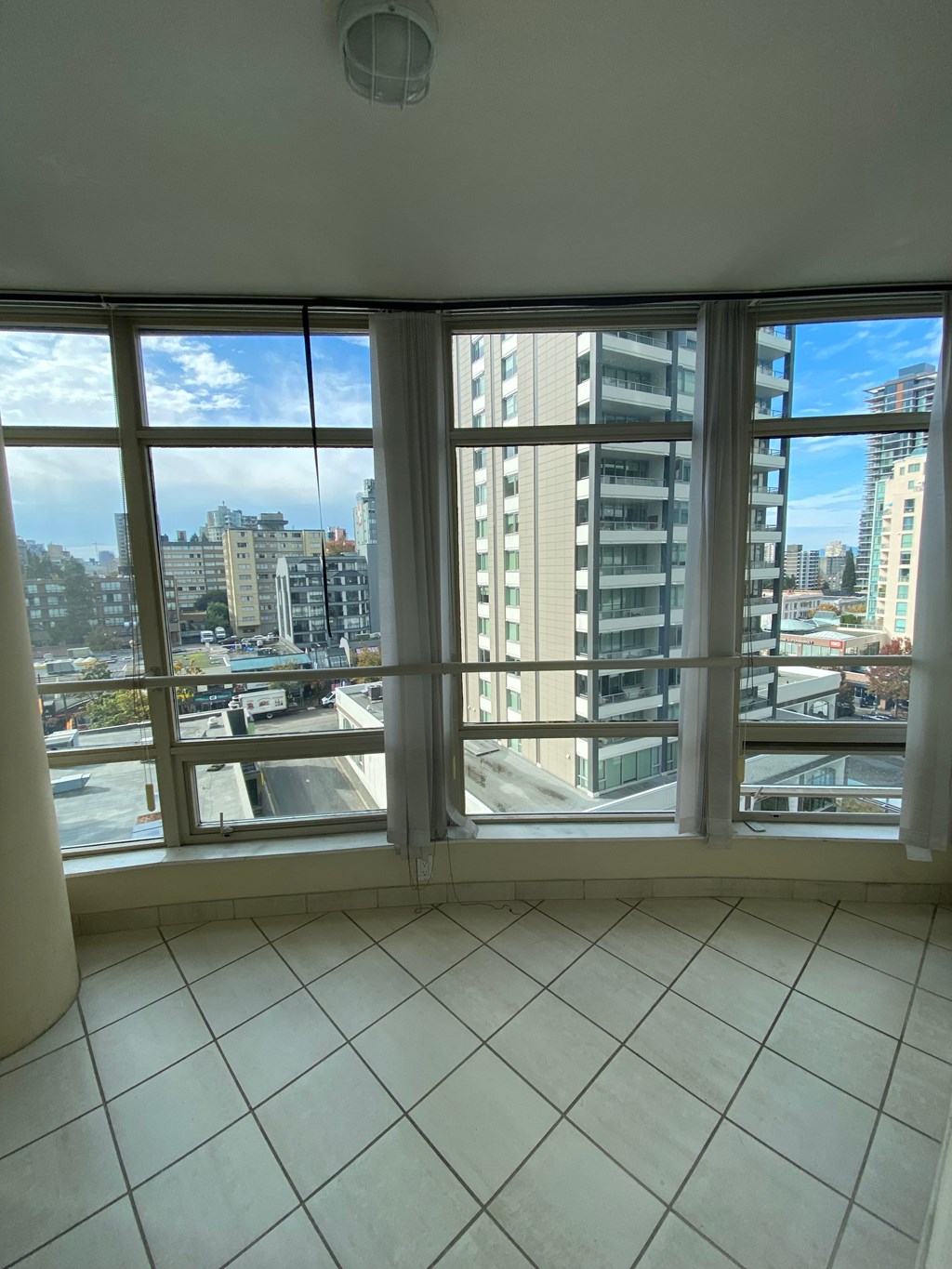 A room with a large window overlooking a cityscape.