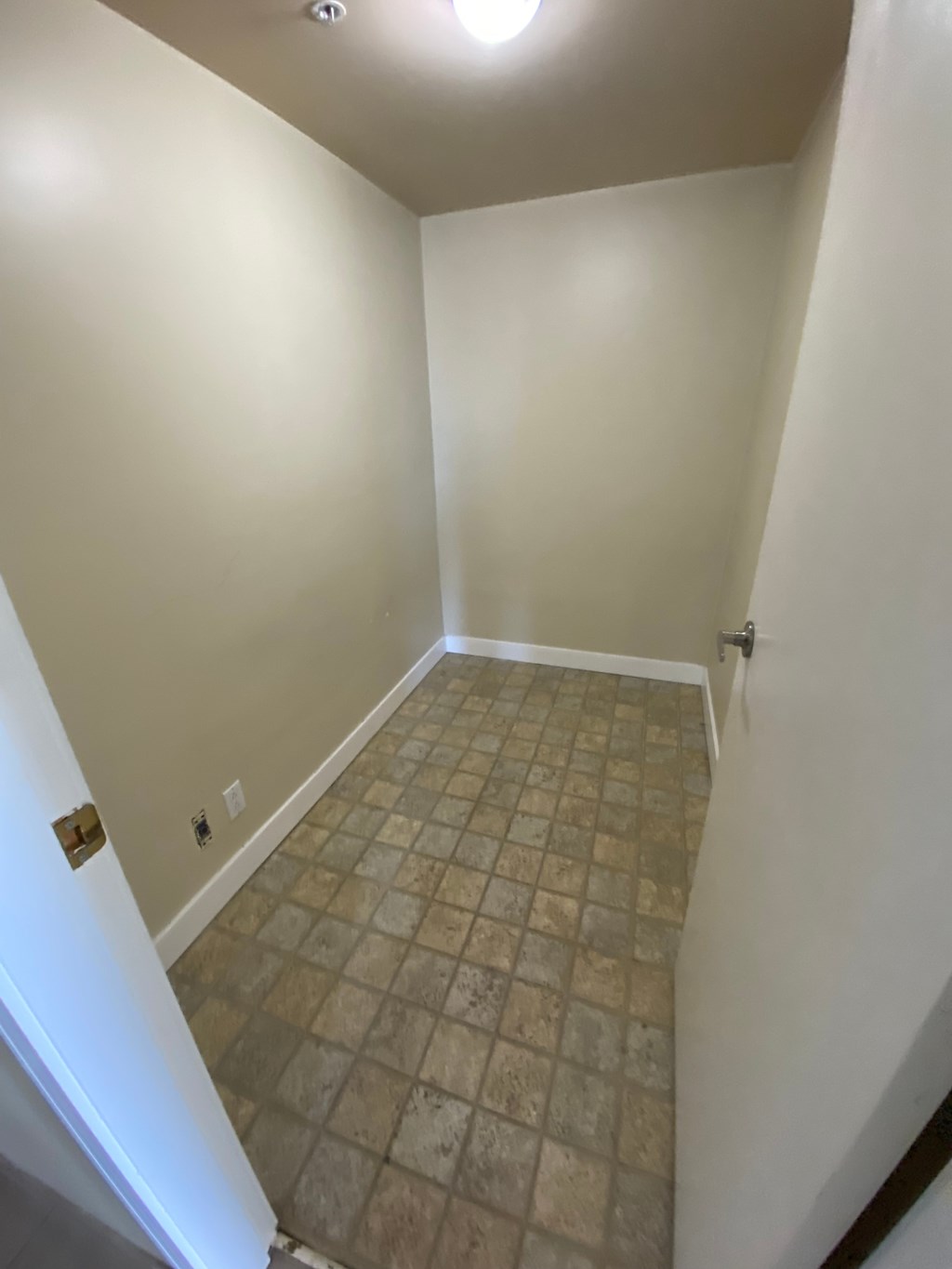 A room with a tiled floor and a light on the ceiling.