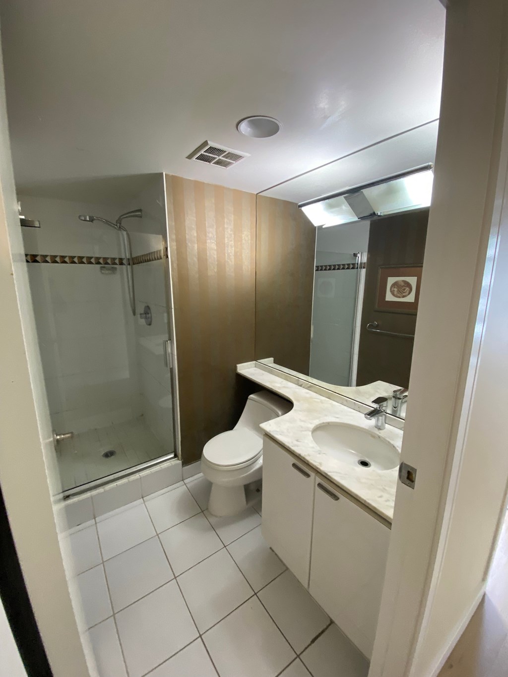 A bathroom with a toilet, sink, and shower.