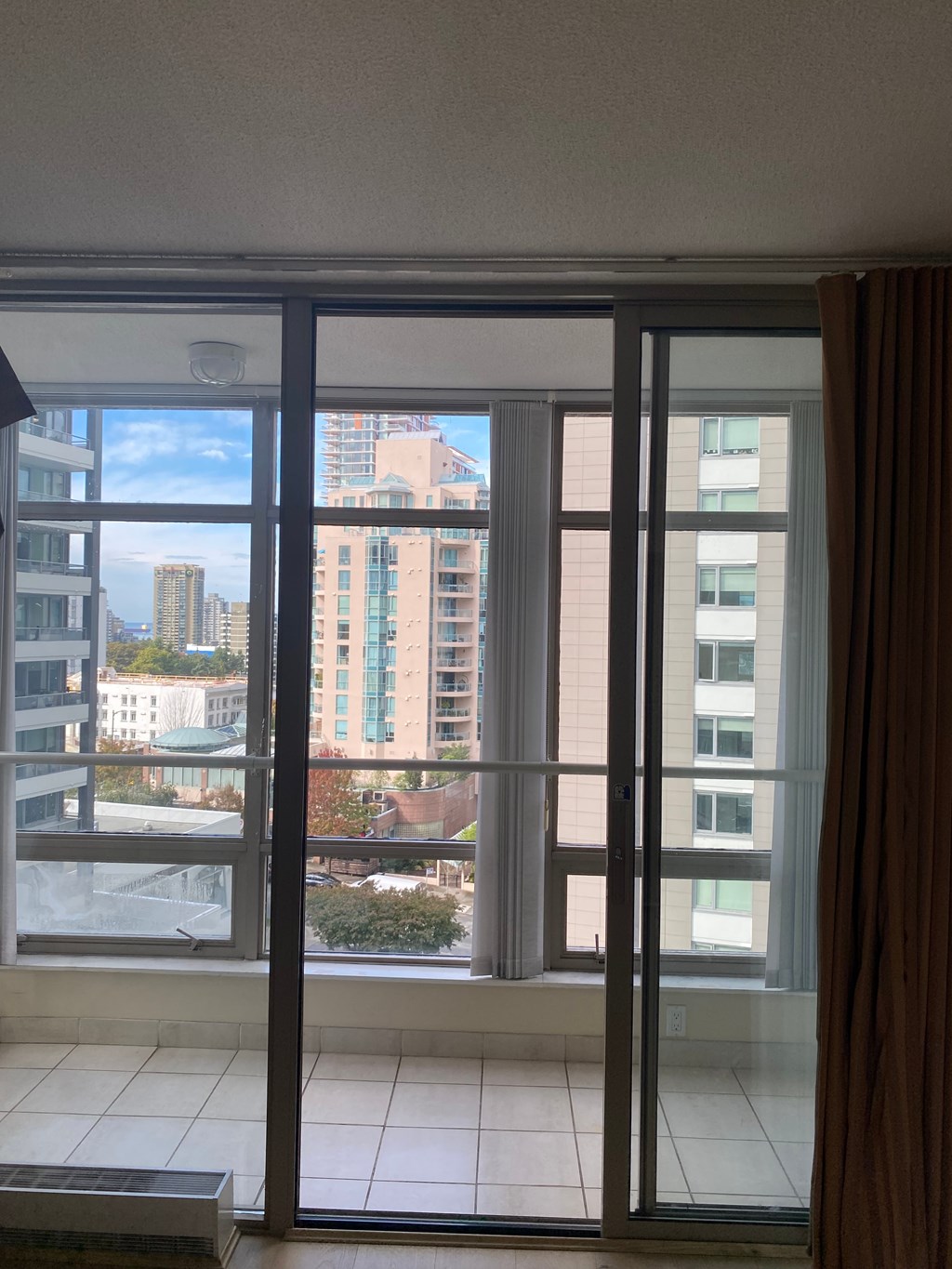 A view of a cityscape through a sliding glass door.