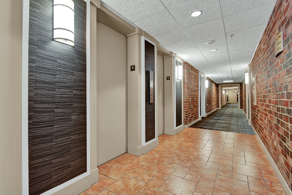 a hallway with a brick wall and wooden doors