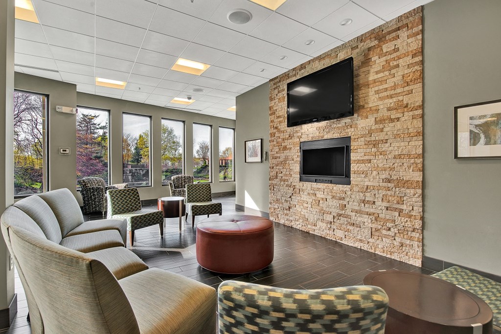 a lobby with couches and chairs and a television
