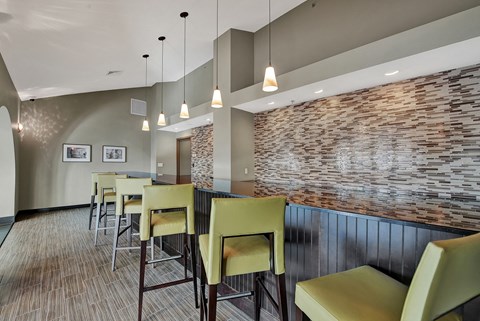 a dining area with a long table and chairs and a brick wall