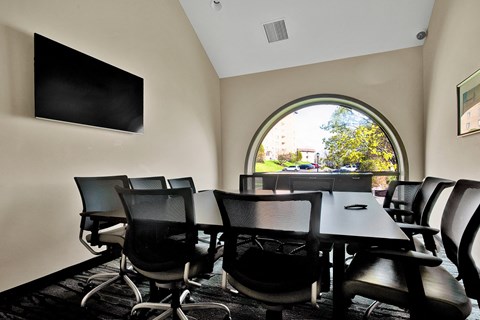 a conference room with a table and chairs and a window