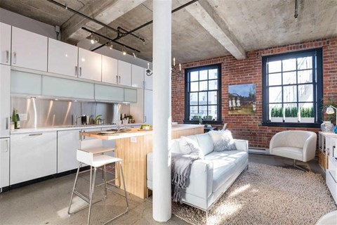 A kitchen with white cabinets and a white chair.