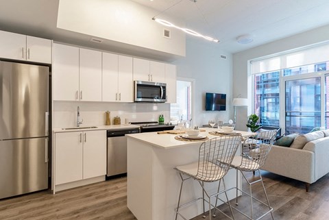 a kitchen and living room with a table and chairs