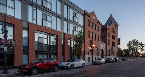 a city street with cars parked in front of a brick building