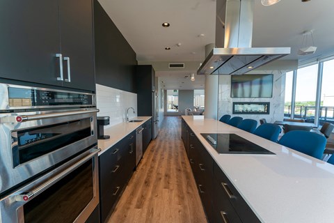 a large kitchen with white counter tops and black cabinets and stainless steel appliances