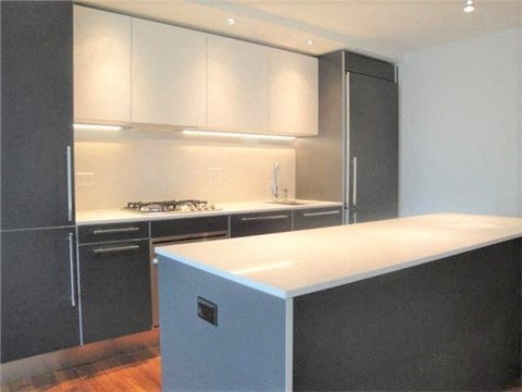 A kitchen with a white counter top and black cabinets.