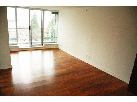 A room with a window and wooden floors.