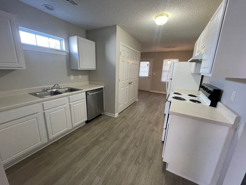 A kitchen with white cabinets and a stove top oven.