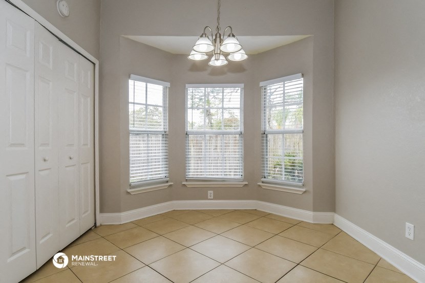 an empty dining room with three windows and a white closet
