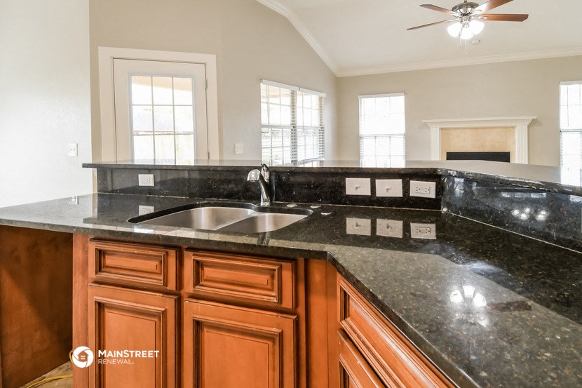 a kitchen with black granite counter tops and a sink