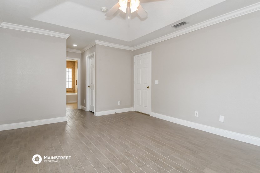 the living room of a new home with a ceiling fan