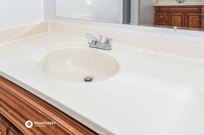a white sink in a bathroom with a mirror