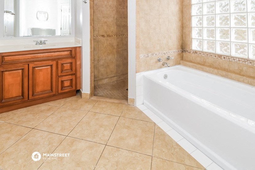 a bathroom with a tub and a sink and a mirror