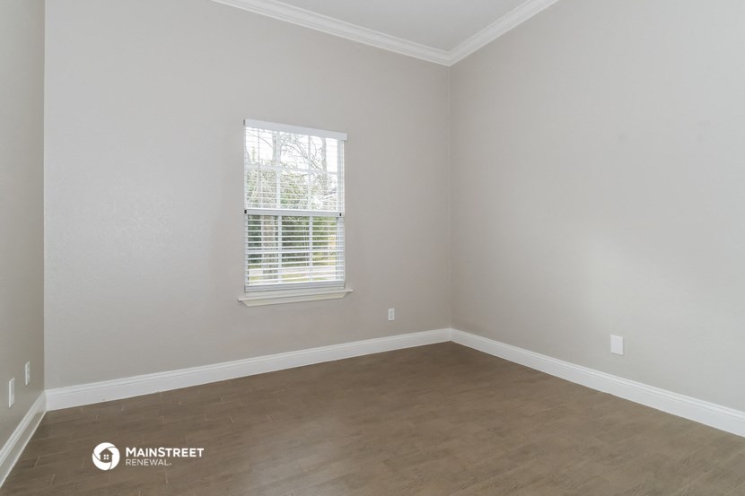 a empty room with wooden floors and a window