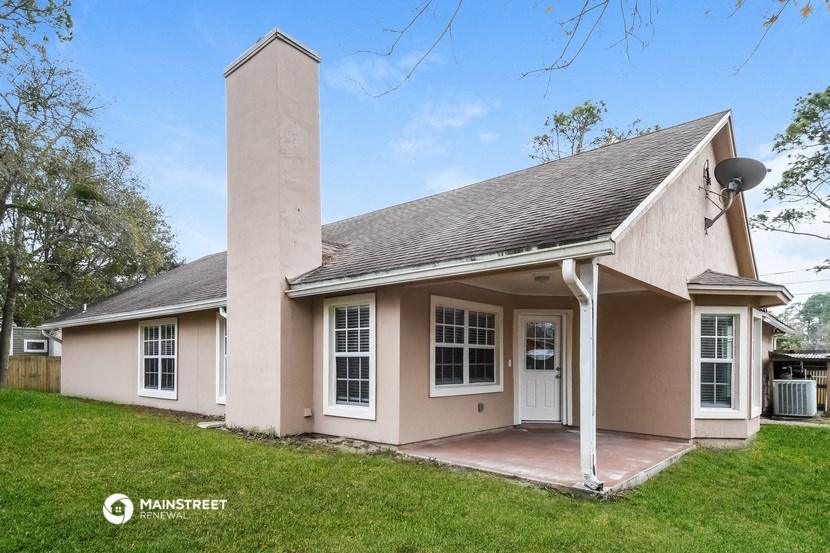 a small tan house with a chimney and a porch