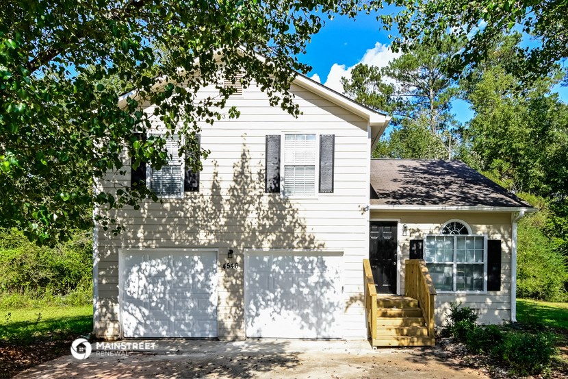 a white house with a garage and a driveway