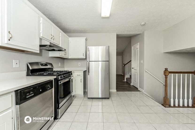 a white kitchen with stainless steel appliances and white cabinets