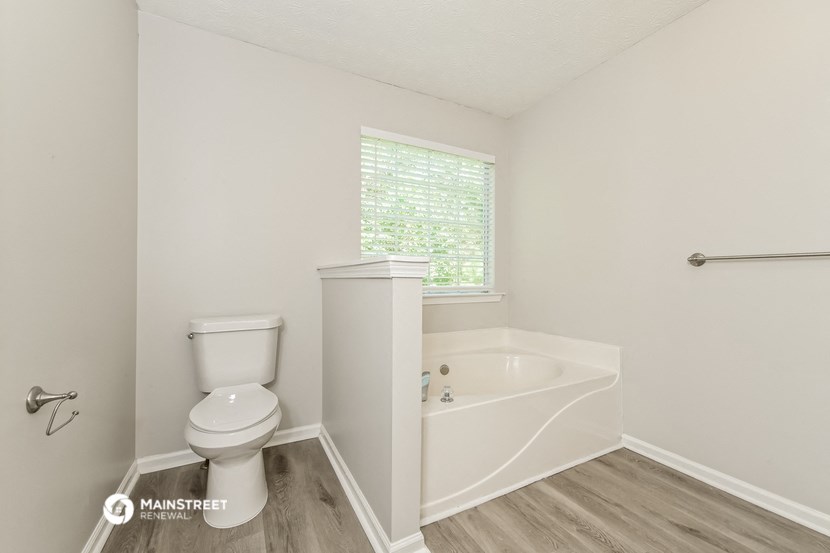 a bathroom with a toilet and a bath tub