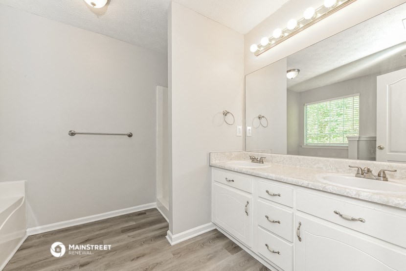 a bathroom with white cabinets and a sink and a mirror