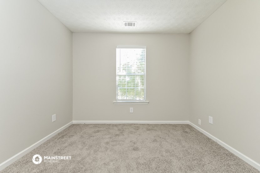 an empty room with carpet and a window