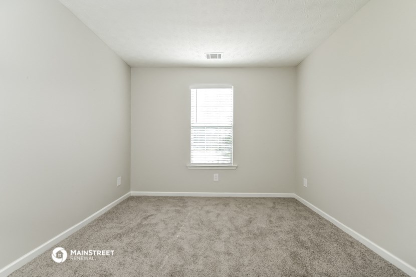 an empty room with carpet and a window