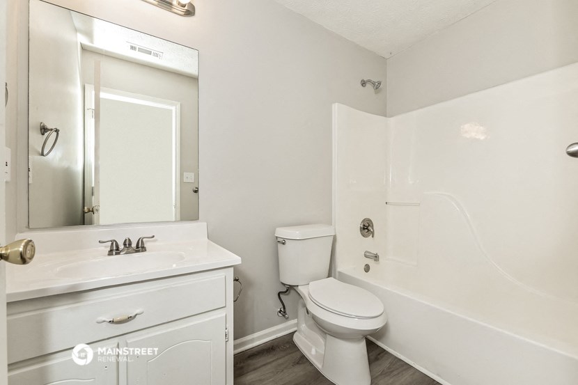 a white bathroom with a toilet and a sink