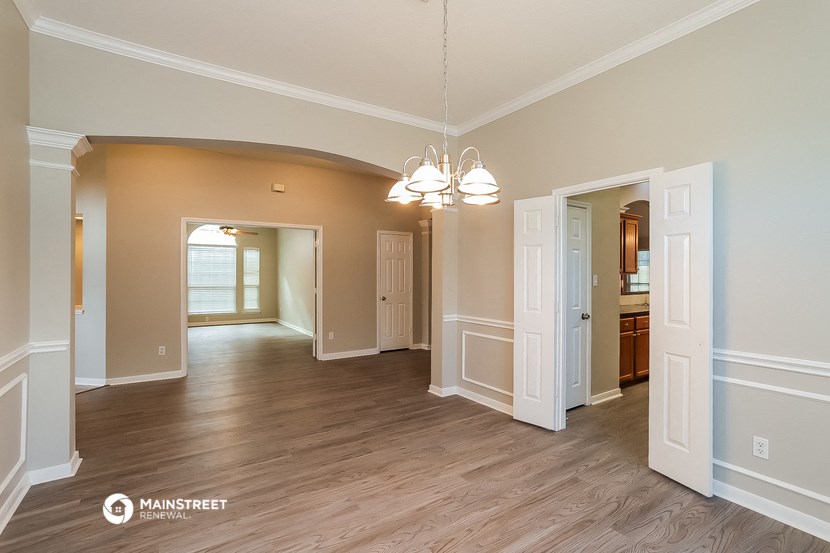 an empty living room and dining room with wood flooring