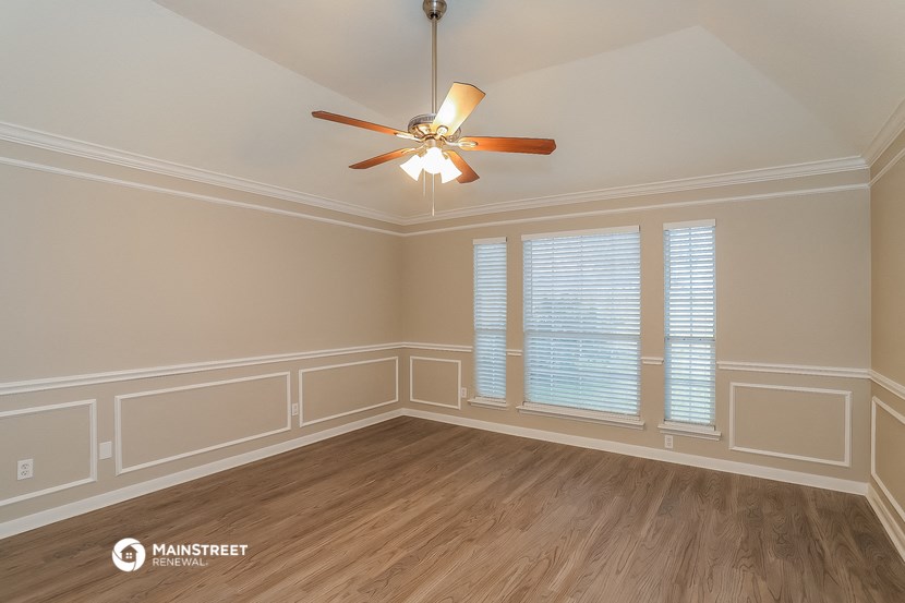 a dining room with white walls and a ceiling fan