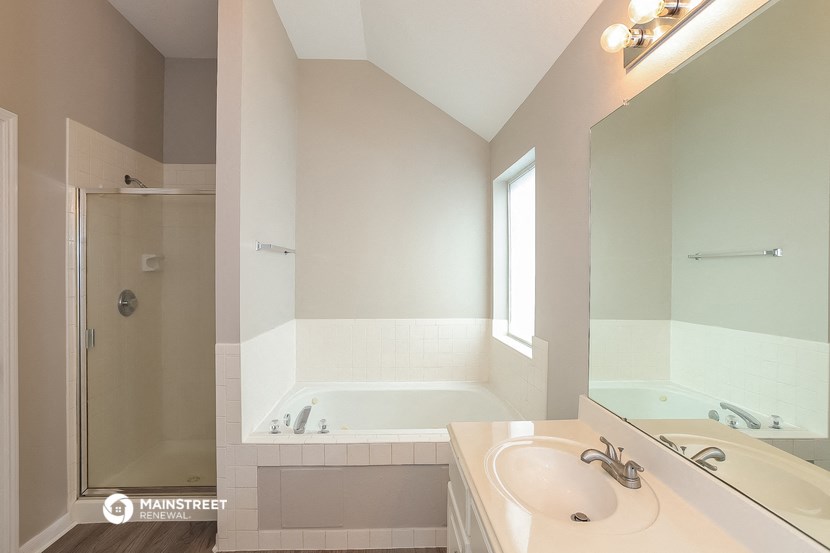 a bathroom with a tub and a sink and a mirror