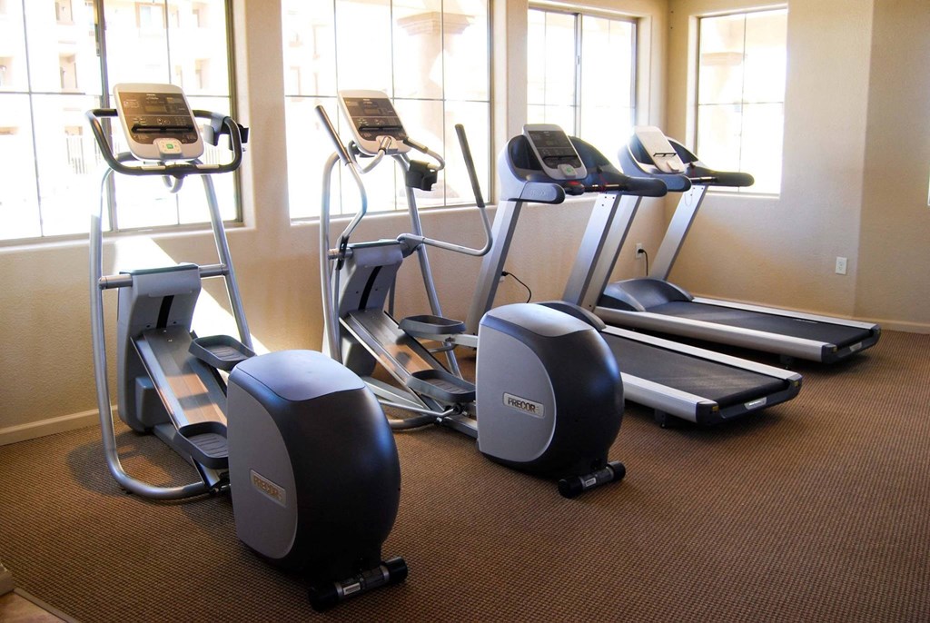 a gym with several pieces of exercise equipment on the floor