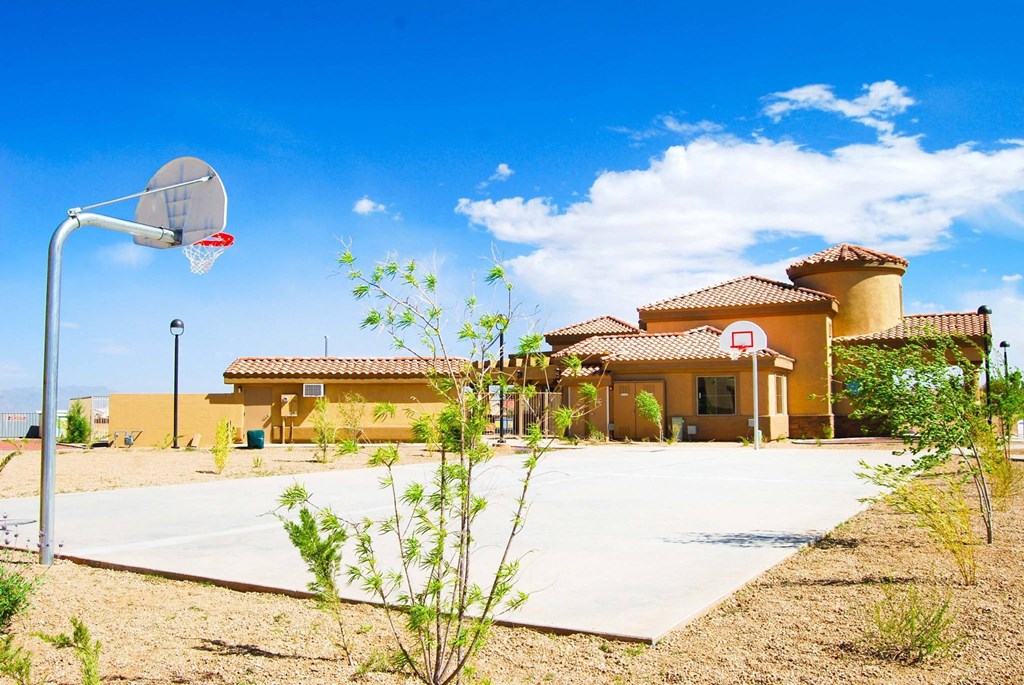 a basketball court in front of a house with a basketball hoop